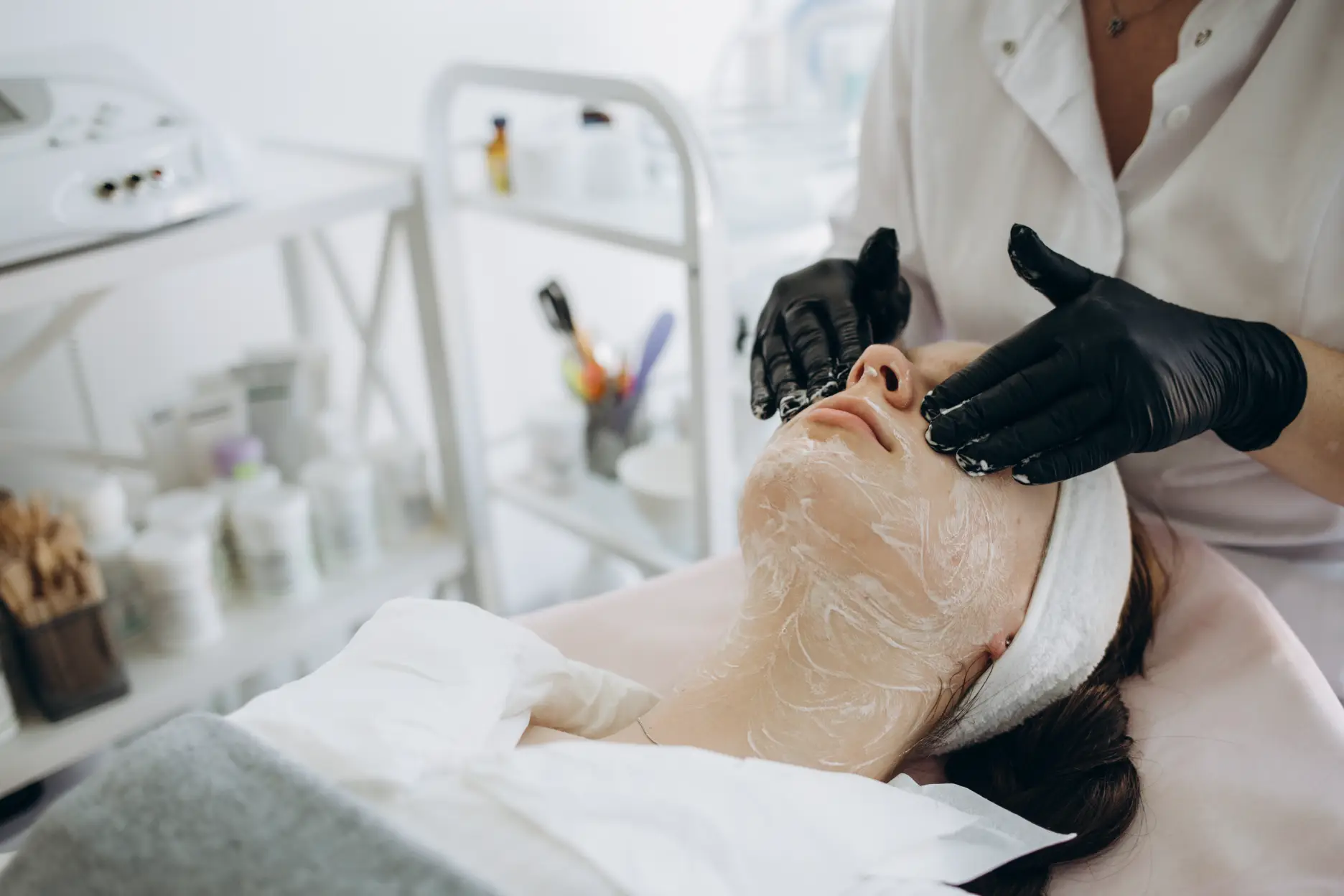 Practitioner massaging cleanser onto woman face